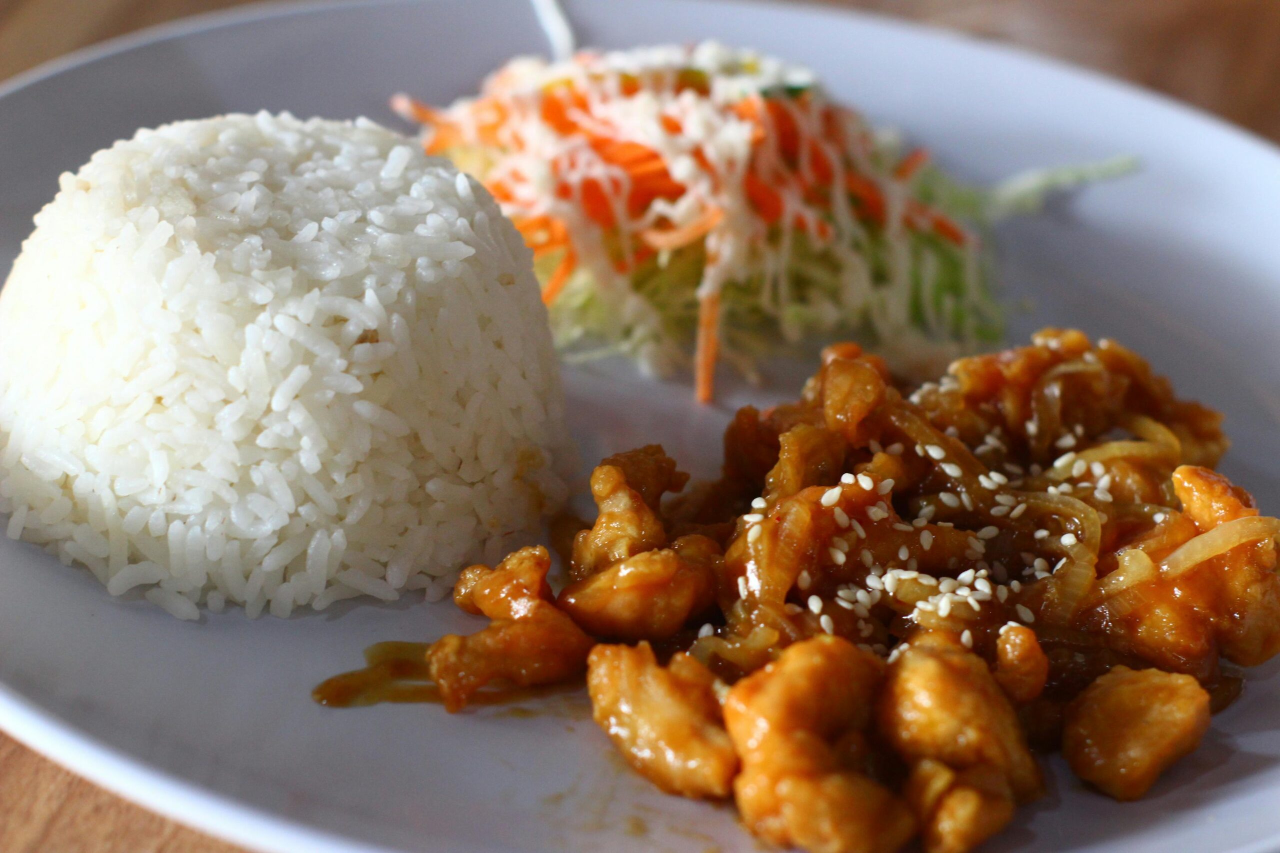 Na slici je poslužen obrok koji se sastoji od kugle bijele riže, porcije salate i piletine u umaku. Riža je savršeno kuhana i poslužena u obliku kupole.