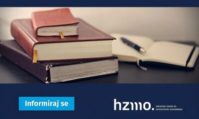 Ova slika prikazuje dvije zatvorene knjige, otvorenu bilježnicu i kemijsku olovku na tamnoj površini. Na slici se također nalazi plavi pravokutnik s tekstom “Informiraj se” i logo “hzmo”.