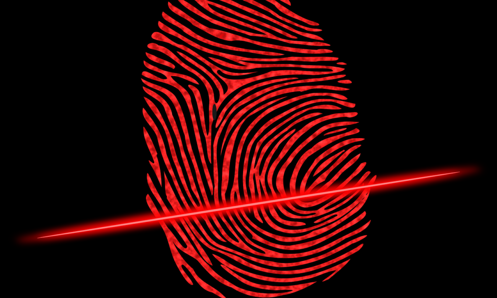 Fotografija prikazuje crveni otisak prsta na crnoj pozadini koji je osvijetljen crvenom svjetlosnom linijom koja prolazi kroz sredinu otiska.