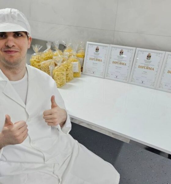 Fotografija prikazuje Petra koji sjedi, obučenog u bijelu radnu odjeću, pokraj njega na bijelom stolu su paketi tjestenine i priznanja koja je dobio za svoj rad. Petar na obje ruke drži palac gore.