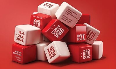 Ova slika prikazuje kolekciju crvenih i bijelih kocki s tekstom na njima, složenih na crvenoj pozadini. Tekst označava događaj nazvan “ZAGREB DOX” zakazan za 14.4. - 21.4.2024. u KAPTOL BOUTIQUE CINEMA & BAR.