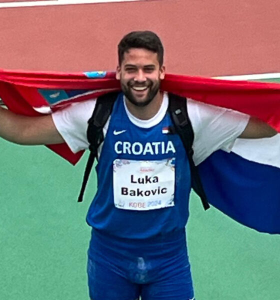 Na slici je osoba koja nosi sportsku opremu s natpisom “Croatia” i ime “Luka Baković”. Osoba drži hrvatsku zastavu raširenu iza sebe.
