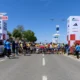 Na slici su trkači koji se pripremaju za utrku. Na jednoj strani piše Zadar Croatia Wings for life i parkiran je automobil na kojem isto piše. S druge strane se vide sponzori utrke, kao što su Adidas i Konzum te također piše World Run. Vide se i crveno bijele kockice.