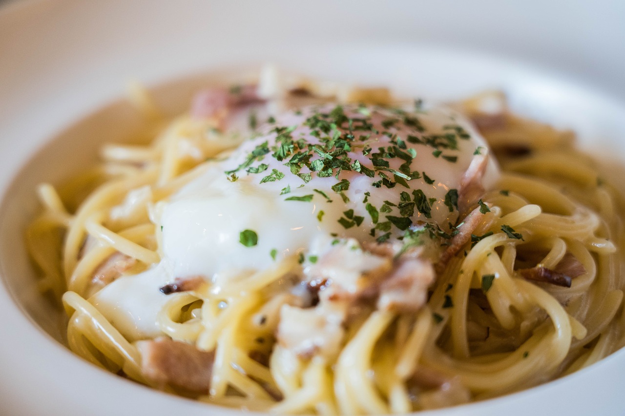 Fotografija prikazuje talijansko jelo špagete carbonara. Izgleda vrlo primamljivo i kremozno.