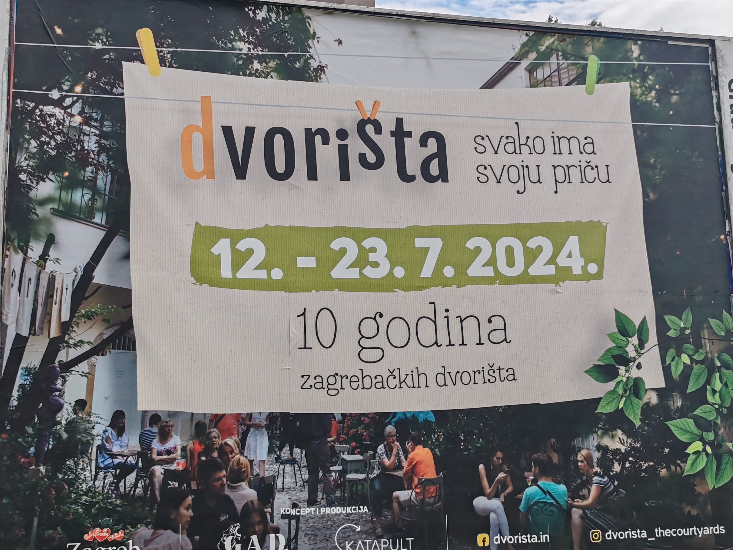 Na slici je plakat za događaj "Dvorišta" koji se održava od 12. do 23. srpnja 2024. godine. Plakat obilježava desetu godišnjicu zagrebačkih dvorišta s natpisom "Svako ima svoju priču." U pozadini plakata je fotografija ljudi koji sjede u dvorištu, uživajući u društvu i opuštenoj atmosferi. Donji dio plakata sadrži logotipe organizatora i kontakte na društvenim mrežama, kao i web stranicu dvorišta.in.