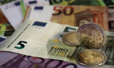 Hrpa euro novčanica različitih apoena (5, 10, 50, 100) i nekoliko euro kovanica (1, 2). Novčanice su naslagane jedna na drugu, dok su kovanice nasumično raspoređene po površini.