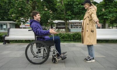 Na slici su dvije osobe muškarac u kolicima i žena koja stoji i pruža ruke jer hoće zagrljaj.