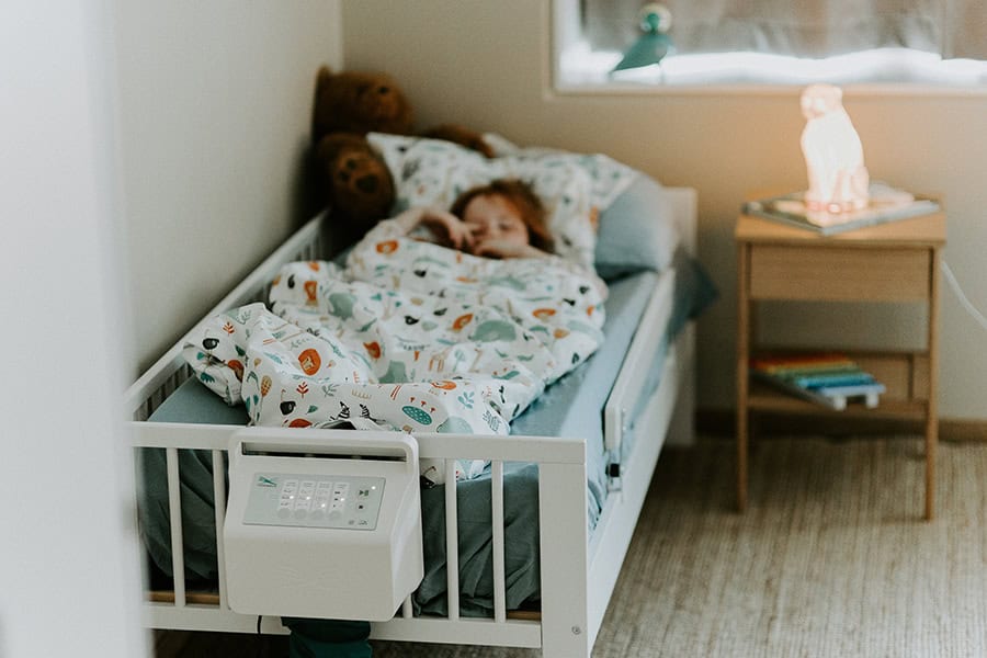 Fotografija prikazuje dijete koje leži u krevetu koji na sebi ima kontolnu ploču.