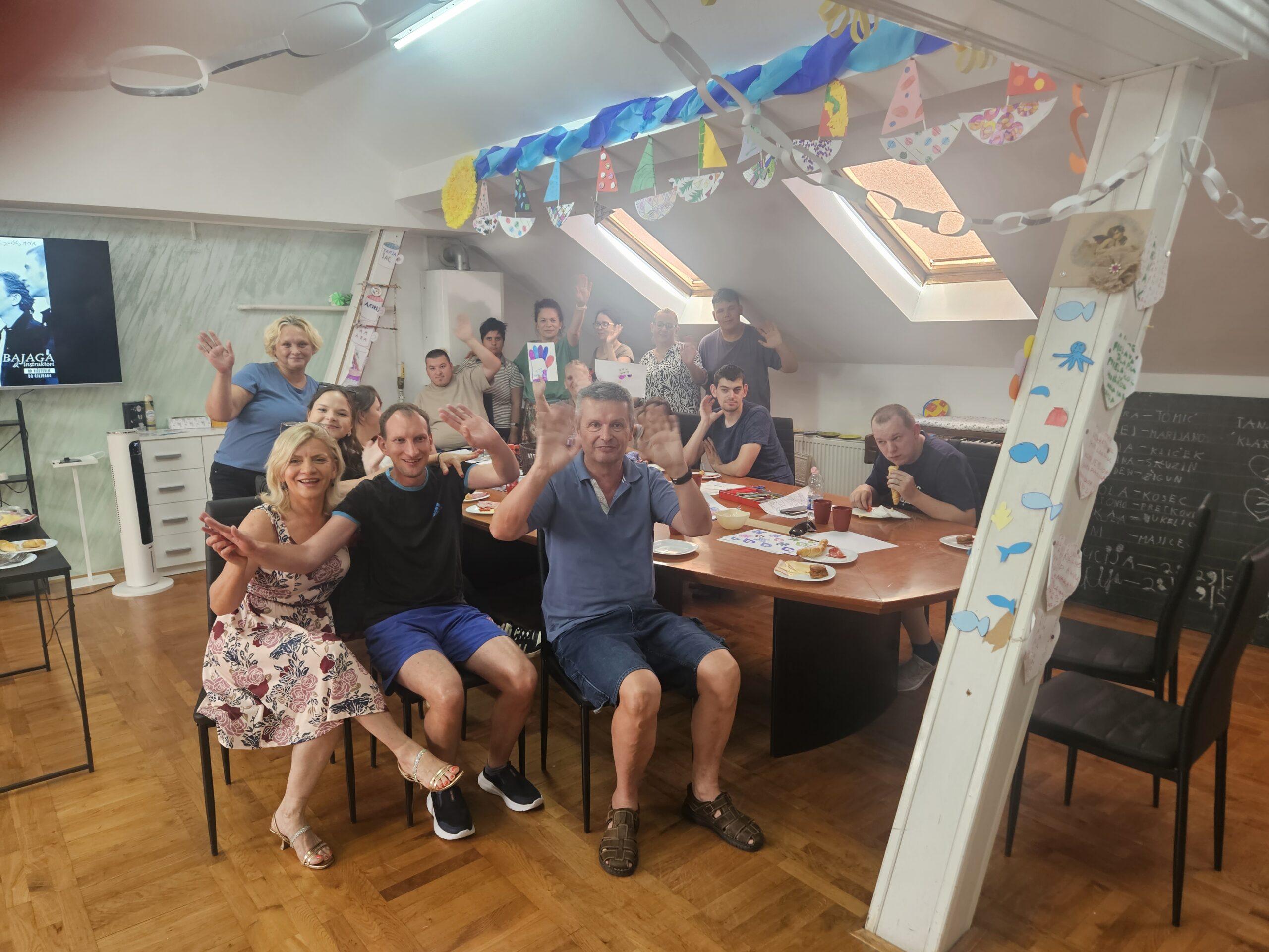 Na slici se vidi vesela i šarena scena iz zatvorenog prostora — vjerojatno učionice ili prostorije za kreativne radionice.