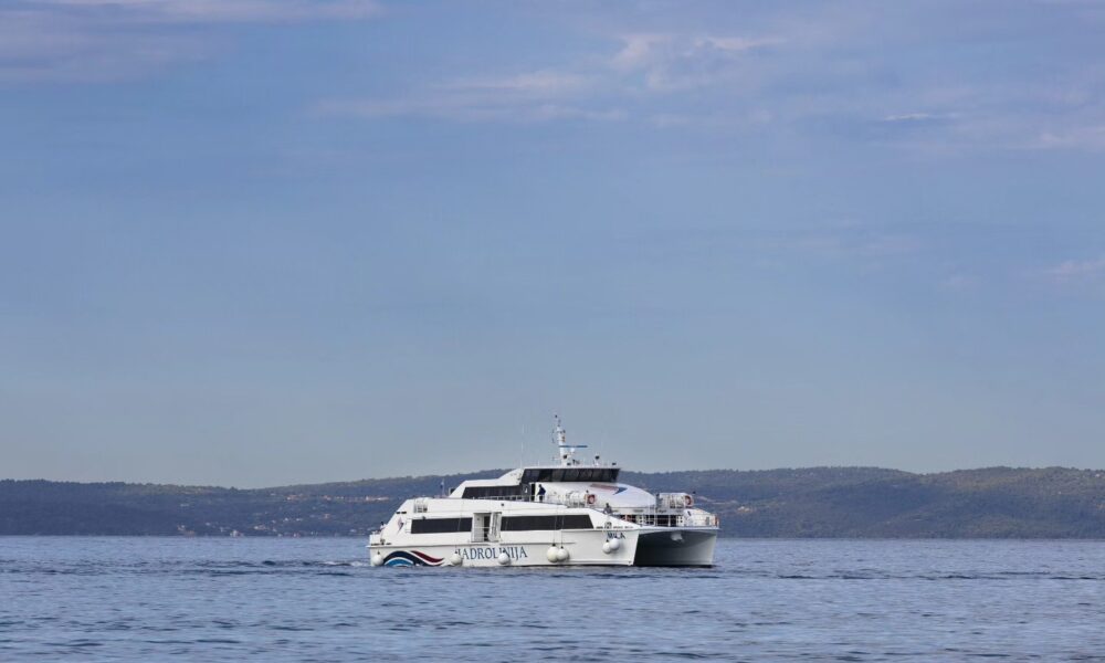 Fotografija prikazuje bijeli brod na pučini na kojem piše 'Jadrolinija'