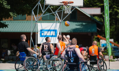 Fotografija prikazuje osobe u kolicima kako igraju košarkašku utakmicu.