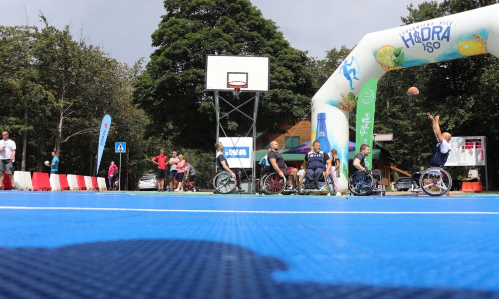 Fotografija prikazuje osobe u invalidskim kolicima kako igraju košarku.