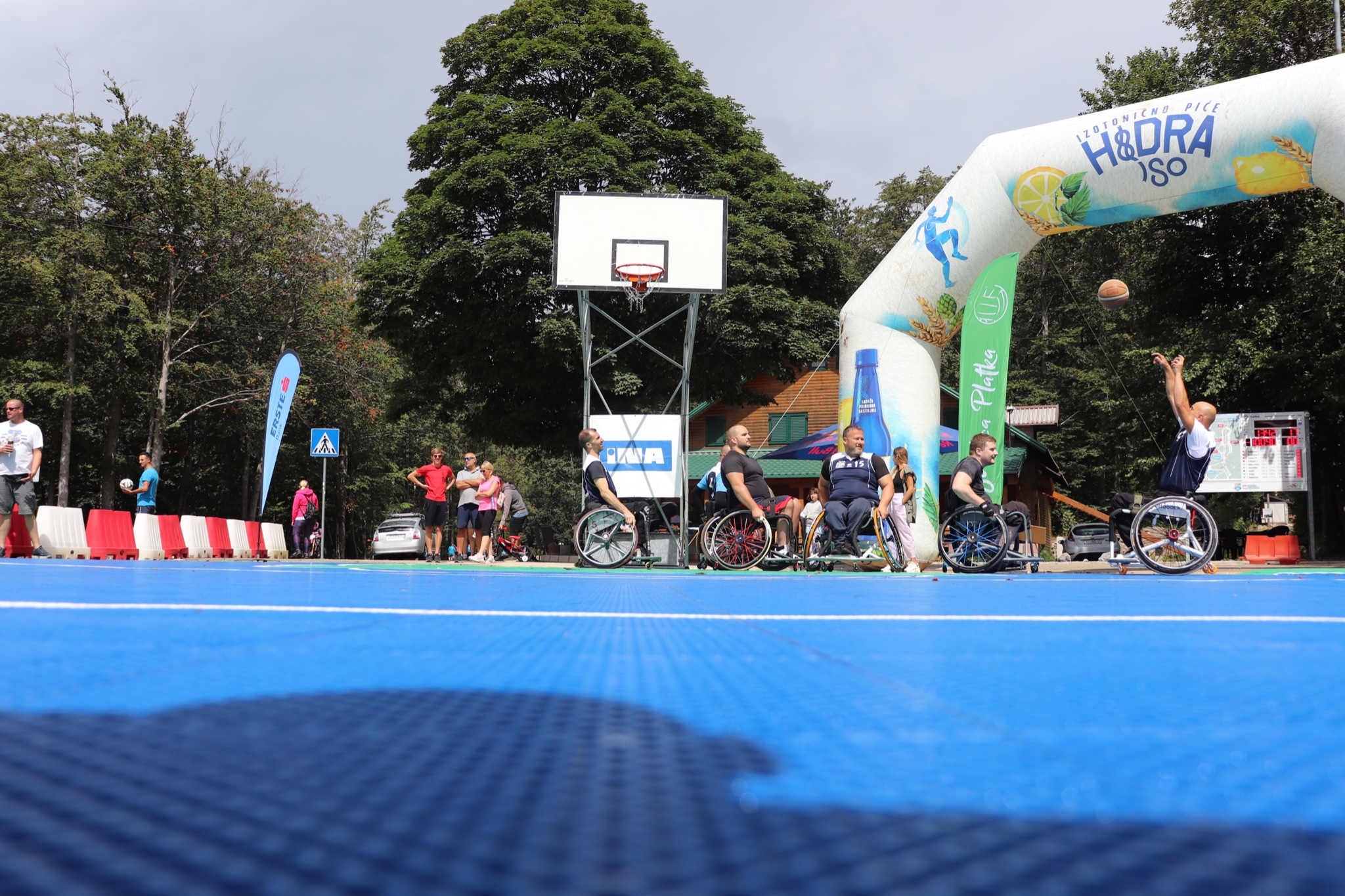 Fotografija prikazuje osobe u invalidskim kolicima kako igraju košarku.