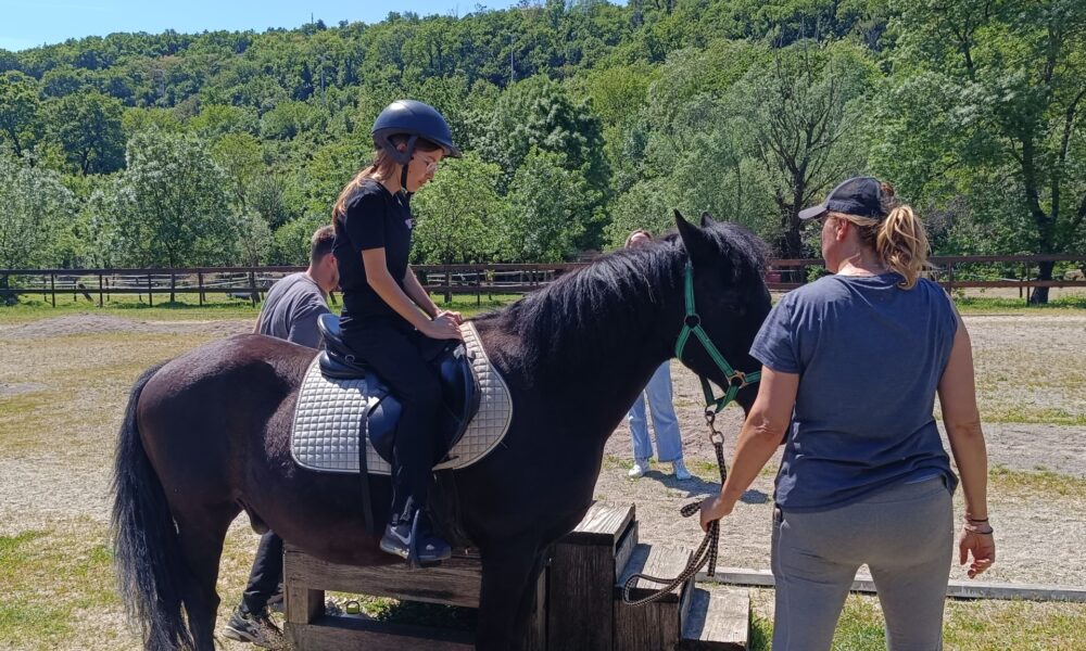 Fotografija prikazuje djevojku na koju koja ima kacigu i netko jiu vodi.