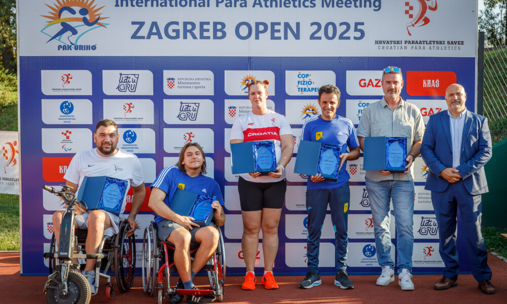 Fotografija prikazuje nekoliko ljudi koji su dobili priznanja. Neki su u invalidskim kolicima neki stoje. Iznad sportaša piše 'Internatinal para atletics Metting Zagreb 2025'.