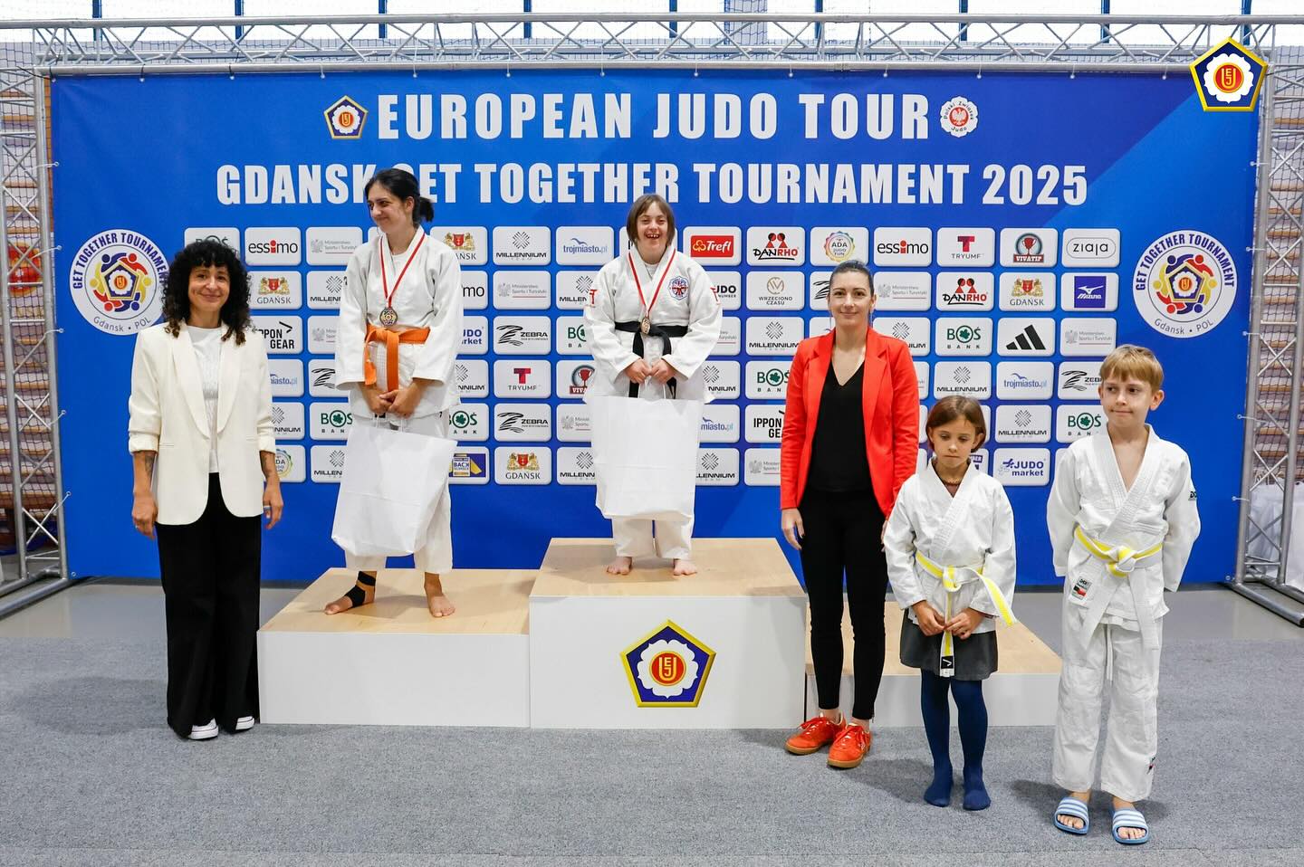 Fotografija prikazuje šest ljudi neki od njuh su u kimonima, dok su dvije ženske osobe u običnoj robi. Ljudi koji stoje na postolju nose medalje. Iza njih se nalazi plakat na kojem je naznačeno da se radi o judu.