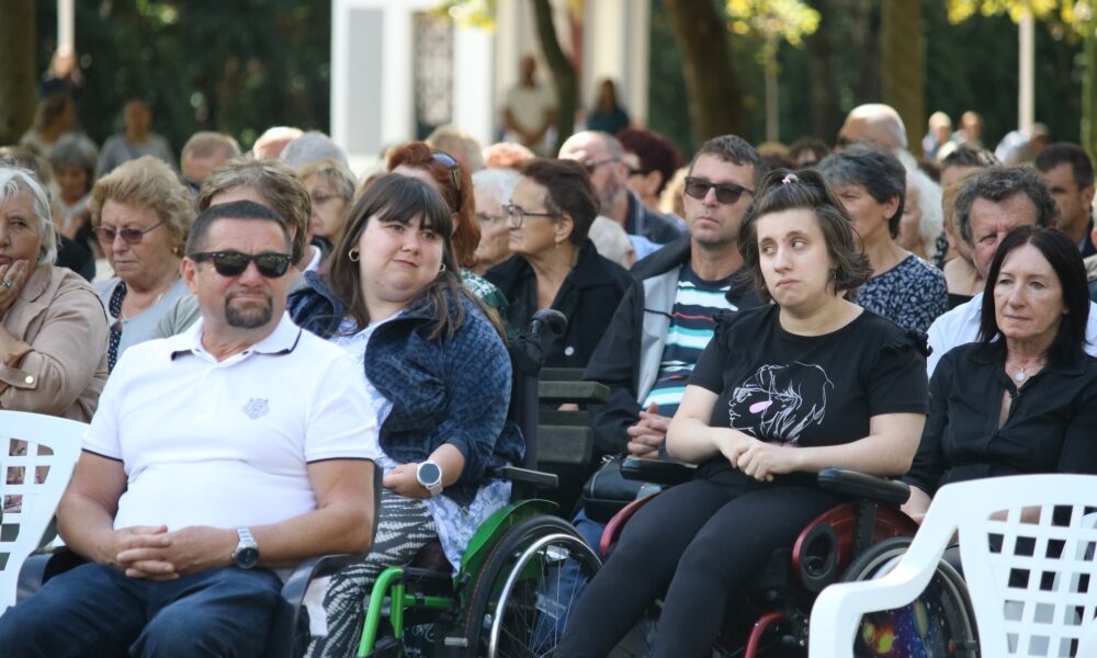 Fotografija prikazuje više ljudi, neki od njih su u invalidskim kolicima.