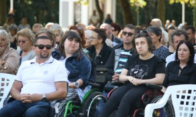 Fotografija prikazuje više ljudi, neki od njih su u invalidskim kolicima.