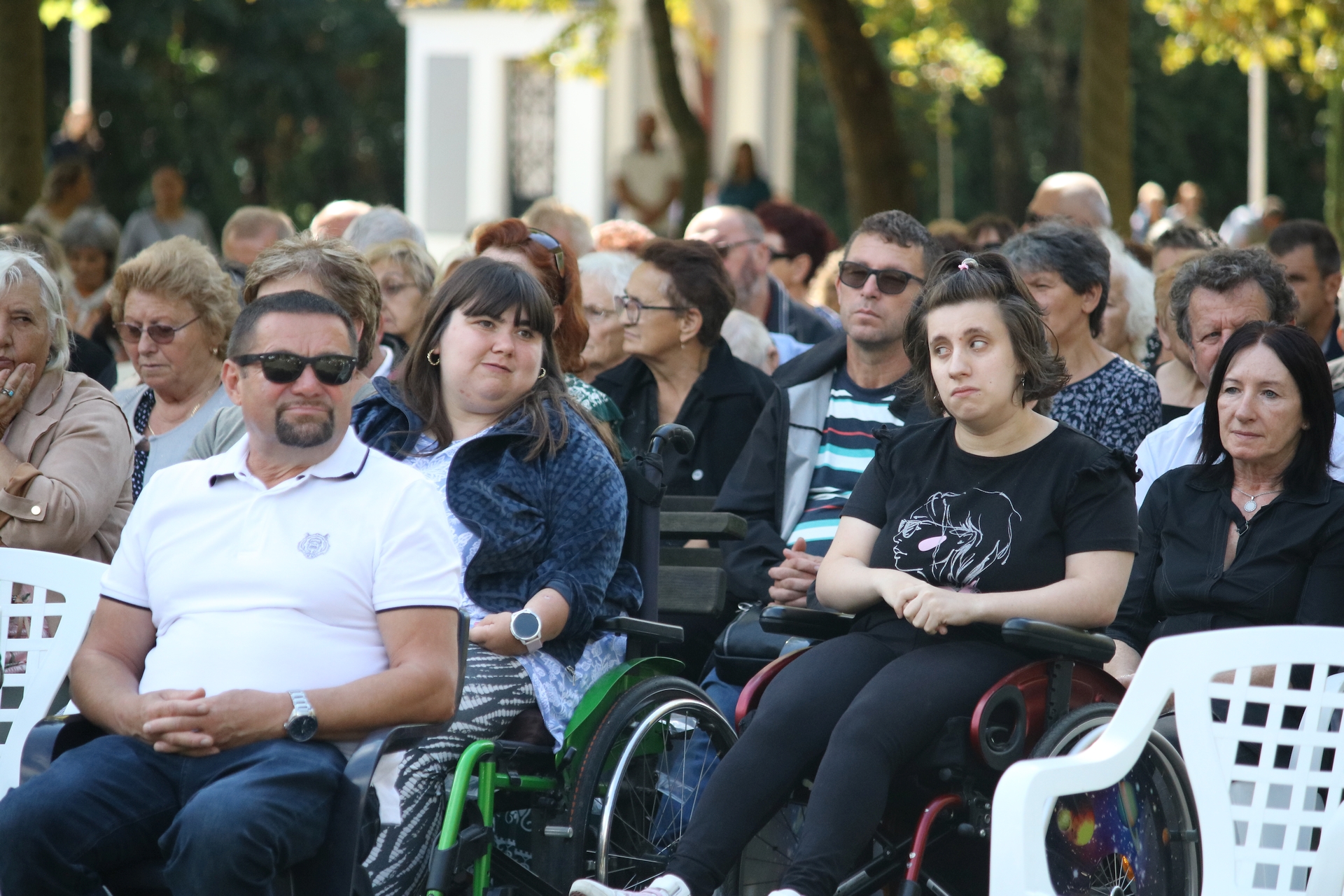 Fotografija prikazuje više ljudi, neki od njih su u invalidskim kolicima.