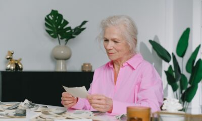 Na fotografiji je žena koja gleda u stare slike.