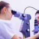 Na fotografiji se prikazuje oftalmološki pregled oka koji provodi zdravstveni djelatnik pomoću biomikroskopa s prorezom (slit lamp). Liječnik pažljivo promatra pacijentovo oko kroz uređaj, koji je opremljen raznim kontrolnim tipkama i kotačićima za podešavanje. Pacijentica sjedi s bradom i čelom oslonjenima na posebne potpornje kako bi glava ostala stabilna tijekom pregleda. Ova scena prikazuje uobičajeni, ali vrlo važan postupak u oftalmologiji, koji omogućuje detaljan pregled prednjeg i stražnjeg segmenta oka. Takvi pregledi pomažu u dijagnosticiranju raznih očnih bolesti i stanja, poput glaukoma, upala, oštećenja rožnice ili mrežnice.