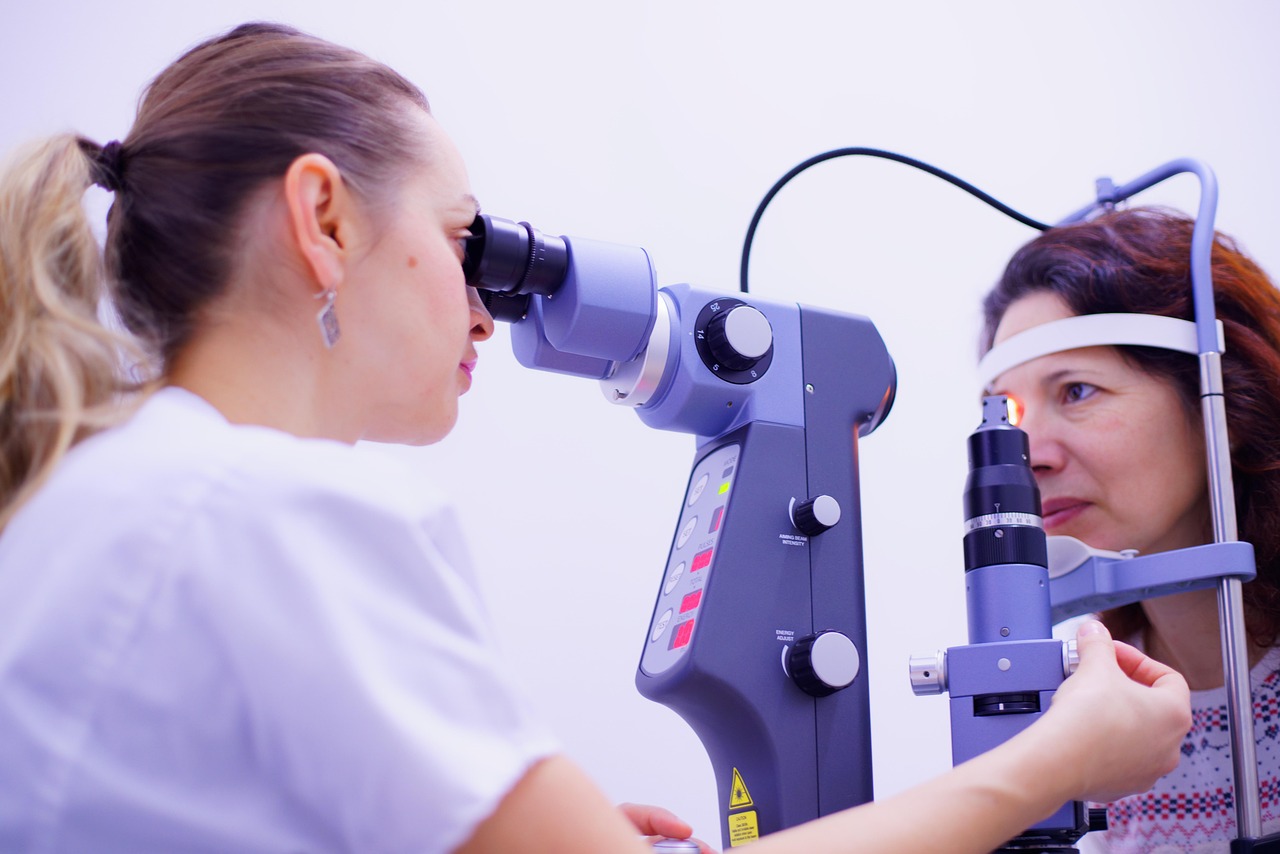 Na fotografiji se prikazuje oftalmološki pregled oka koji provodi zdravstveni djelatnik pomoću biomikroskopa s prorezom (slit lamp). Liječnik pažljivo promatra pacijentovo oko kroz uređaj, koji je opremljen raznim kontrolnim tipkama i kotačićima za podešavanje. Pacijentica sjedi s bradom i čelom oslonjenima na posebne potpornje kako bi glava ostala stabilna tijekom pregleda. Ova scena prikazuje uobičajeni, ali vrlo važan postupak u oftalmologiji, koji omogućuje detaljan pregled prednjeg i stražnjeg segmenta oka. Takvi pregledi pomažu u dijagnosticiranju raznih očnih bolesti i stanja, poput glaukoma, upala, oštećenja rožnice ili mrežnice.