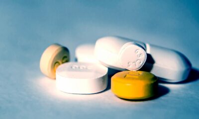 Na fotografiji se nalazi nekoliko tableta i kapsula raznih oblika, boja i veličina, raspoređenih po ravnoj površini. Među njima su bijele, žute i bež tablete — neke su okrugle, a druge izdužene. Na pojedinim tabletama vidljive su oznake poput "C 5" i "20", koje obično označavaju vrstu lijeka i njegovu jačinu.