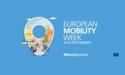 Na fotografiji se nalazi službeni vizual Europskog tjedna mobilnosti. Pozadina je plave boje, a u sredini dominira velika ikona u obliku lokatora (oznaka položaja na karti). Unutar te ikone prikazane su razne scene koje simboliziraju održivu mobilnost – ljudi koji hodaju, voze bicikl, koriste javni prijevoz i kretanje osoba s invaliditetom. Desno od ilustracije nalazi se natpis „European Mobility Week“ s datumom 16–22 September, dok je ispod istaknut hashtag #MobilityWeek. U donjem desnom kutu smještena je zastava Europske unije, koja označava organizatora i pokrovitelja kampanje. Vizual naglašava poruku kampanje – poticanje građana na održive, uključive i ekološki prihvatljive oblike kretanja.