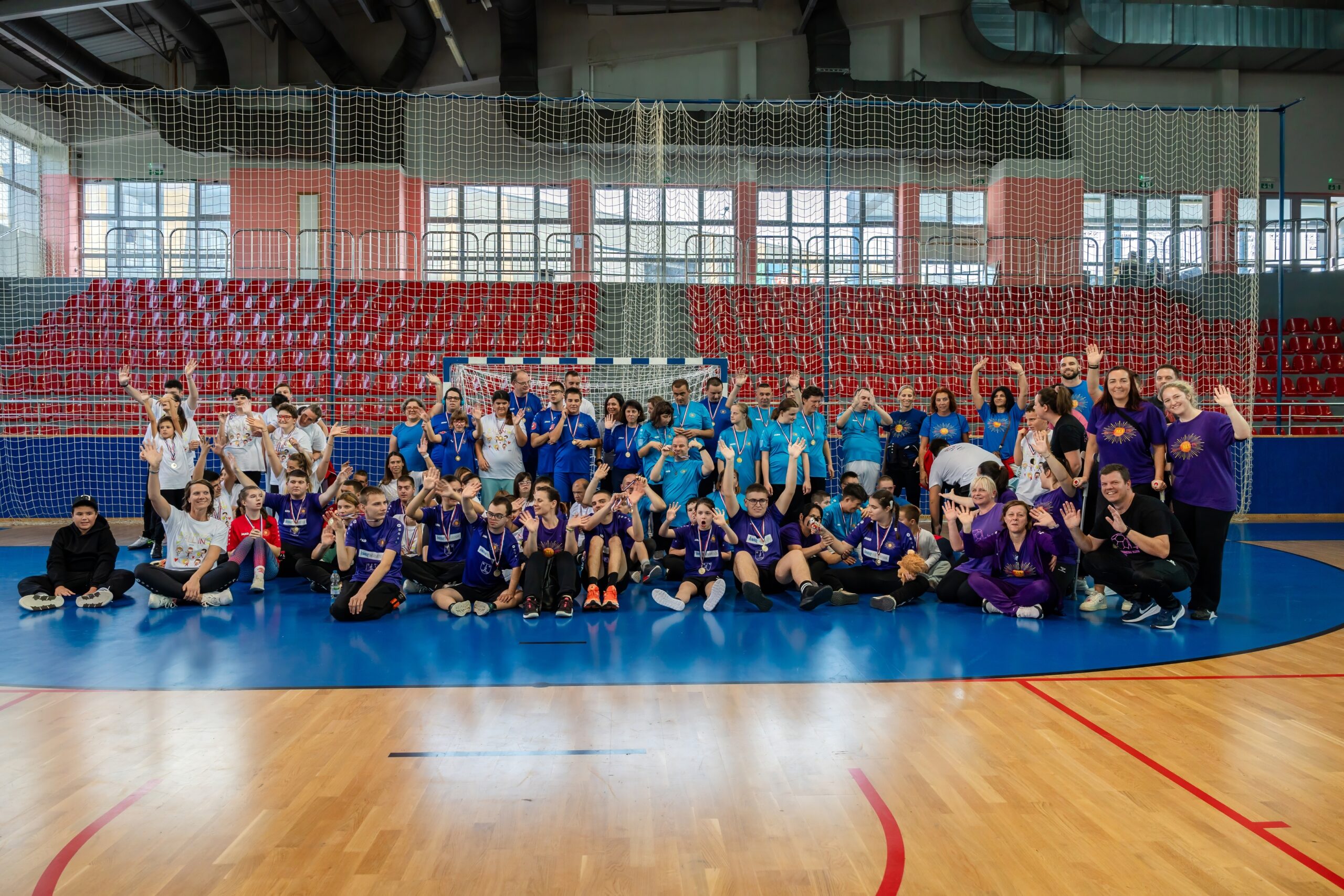 Fotografija prikazuje djecu s teškoćama u razvoju u sportskoj dvorani s medaljama oko vrata.