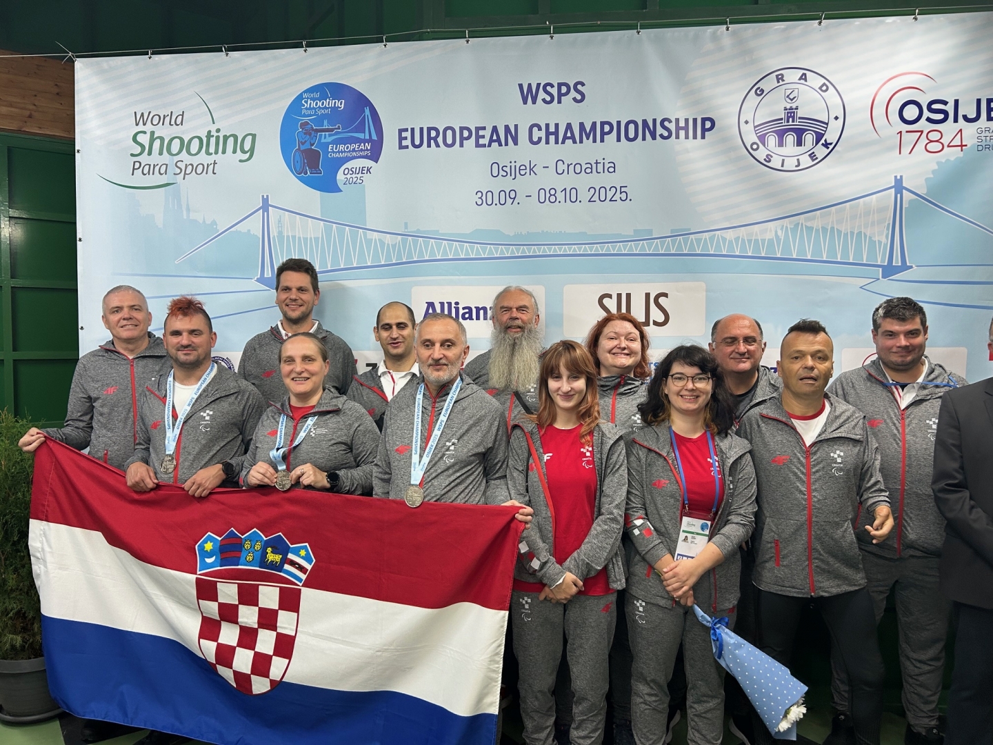 Na fotografiji su ljudi koji oko vrata nose srebrne medalje, a neki od njih razvili su hrvatsku zastavu.