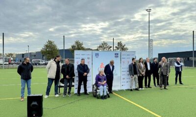 Fotografija prikazuje nekoliko ljudi lijepoi obučenih na sportskom igralištu. Jedna osoba je u invalidskim kolicima, dok drugi stoje.