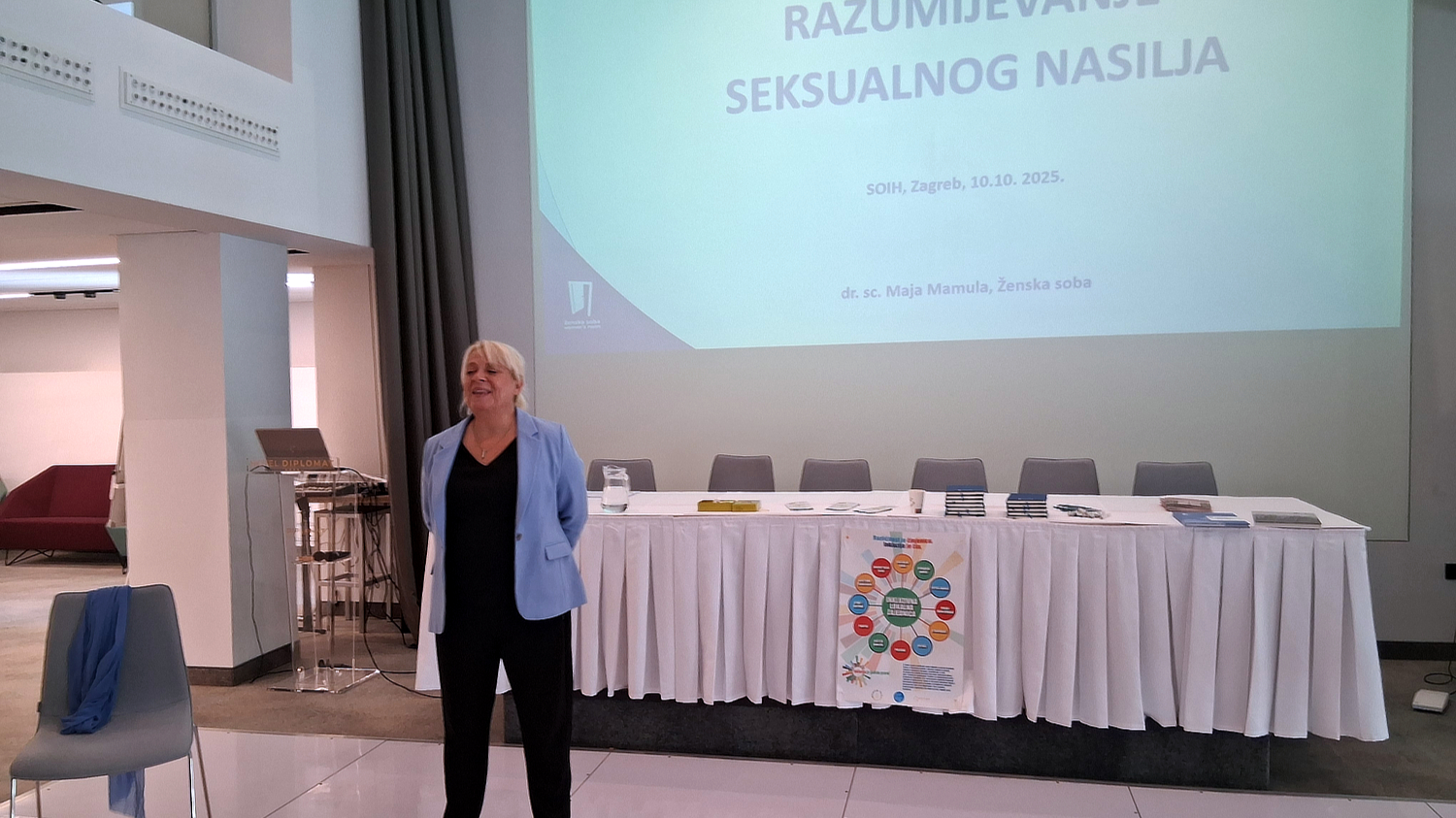 Govornica stoji ispred projekcijskog platna s natpisom „Razumijevanje seksualnog nasilja” tijekom edukacije u organizaciji SOIH-a u Zagrebu, 10. listopada 2025. godine.