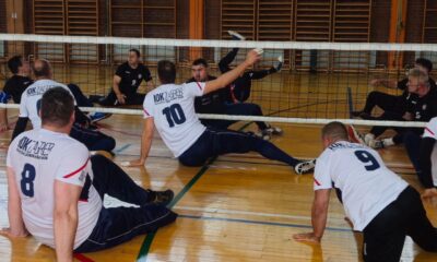 Fotografija prikazuje dvije ekipe kako igraju sjedeću odbojku.