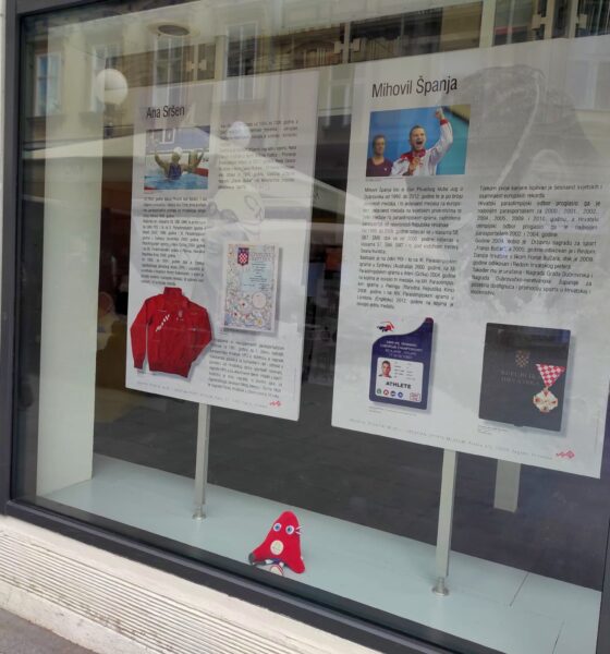 Fotografija prikazuje izlog na kojem su izložena dva papira na kojem pišu informacije o paraplivačima.