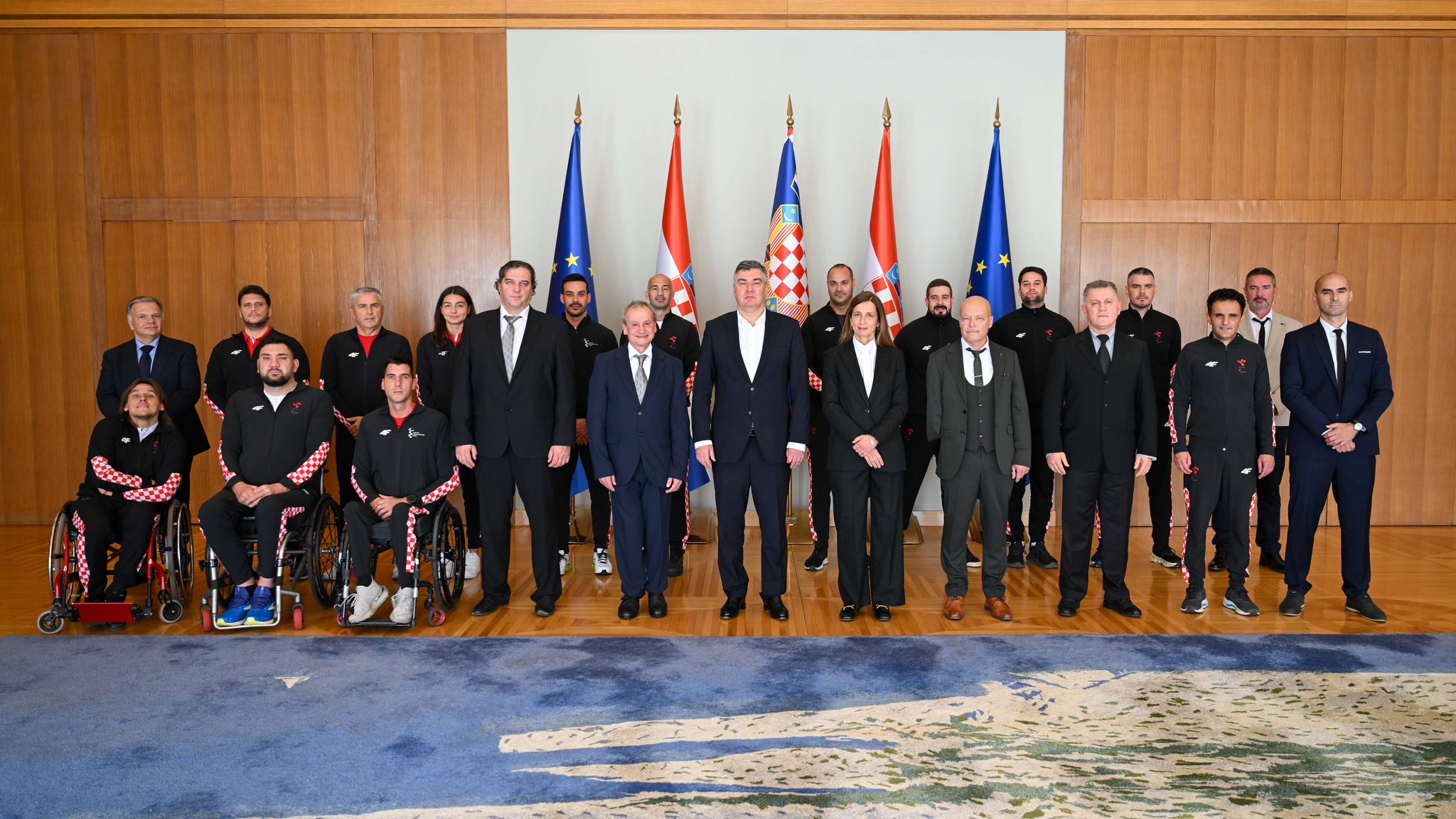 Fotografija prikazuje više ljudi u uredu nekog visokog dužnosnika, neki od njih su u invalidskim kolicima.