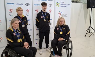 Slika prikazuje četiri osobe s medaljama oko vrata od kojih su dvije u invalidskim kolicima.