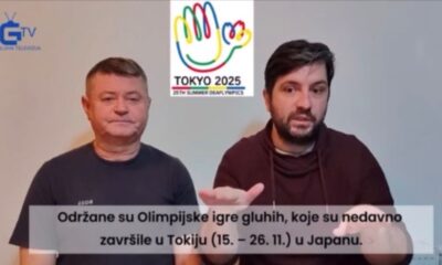 Na fotografiji se nalaze dva muškarca koji stoje jedan uz drugoga ispred jednostavne pozadine. Lijevo je logotip „GTV GLUHA TELEVIZIJA“, koji označava televizijski kanal namijenjen gluhima. U gornjem središnjem dijelu slike nalazi se šareni logotip s motivom stilizirane ruke i leptira, ispod kojeg piše „TOKYO 2025 25TH SUMMER DEAFLYMPICS“, što upućuje na predstojeće Ljetne olimpijske igre za gluhe koje će se održati u Tokiju 2025. godine. Muškarac s desne strane koristi znakovni jezik, što dodatno naglašava temu komunikacije unutar zajednice gluhih. Donji dio fotografije sadrži natpis na hrvatskom jeziku: „Održane su Olimpijske igre gluhih, koje su nedavno završile u Tokiju (15. – 26. 11.) u Japanu“, čime se potvrđuje da je događaj već održan. Fotografija prenosi snažnu poruku o inkluziji, medijskoj vidljivosti i međunarodnoj suradnji u kontekstu sporta i zajednice gluhih.