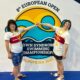 Fotografija prikazuje dvije osobe s Down sindromom kako se drže za ruke. Iza njih stoji logo natjecanja na kojem piše '8 European open'.