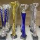 Fotografija prikazuje pehare koji stoje na stolu. Ima nekoliko srebrno-plavih pehara, jedan zlatni i nekoliko srebrnih