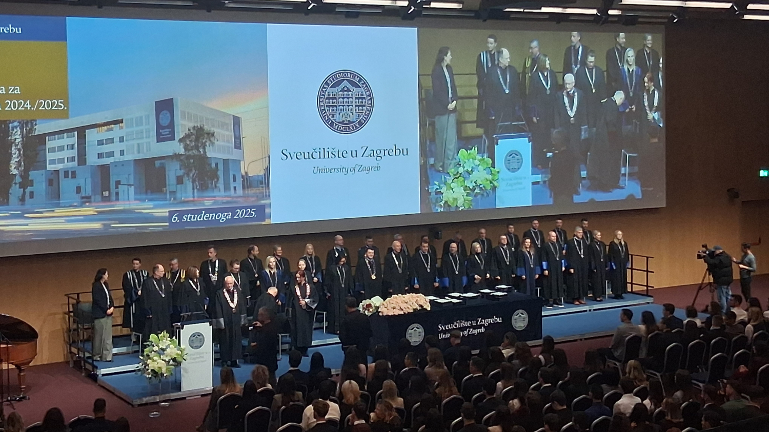 Svečana dodjela Rektorove nagrade na Sveučilištu u Zagrebu, s nizom sveučilišnih dužnosnika u akademskim odorama na pozornici ispred velikog ekrana s logotipom Sveučilišta.