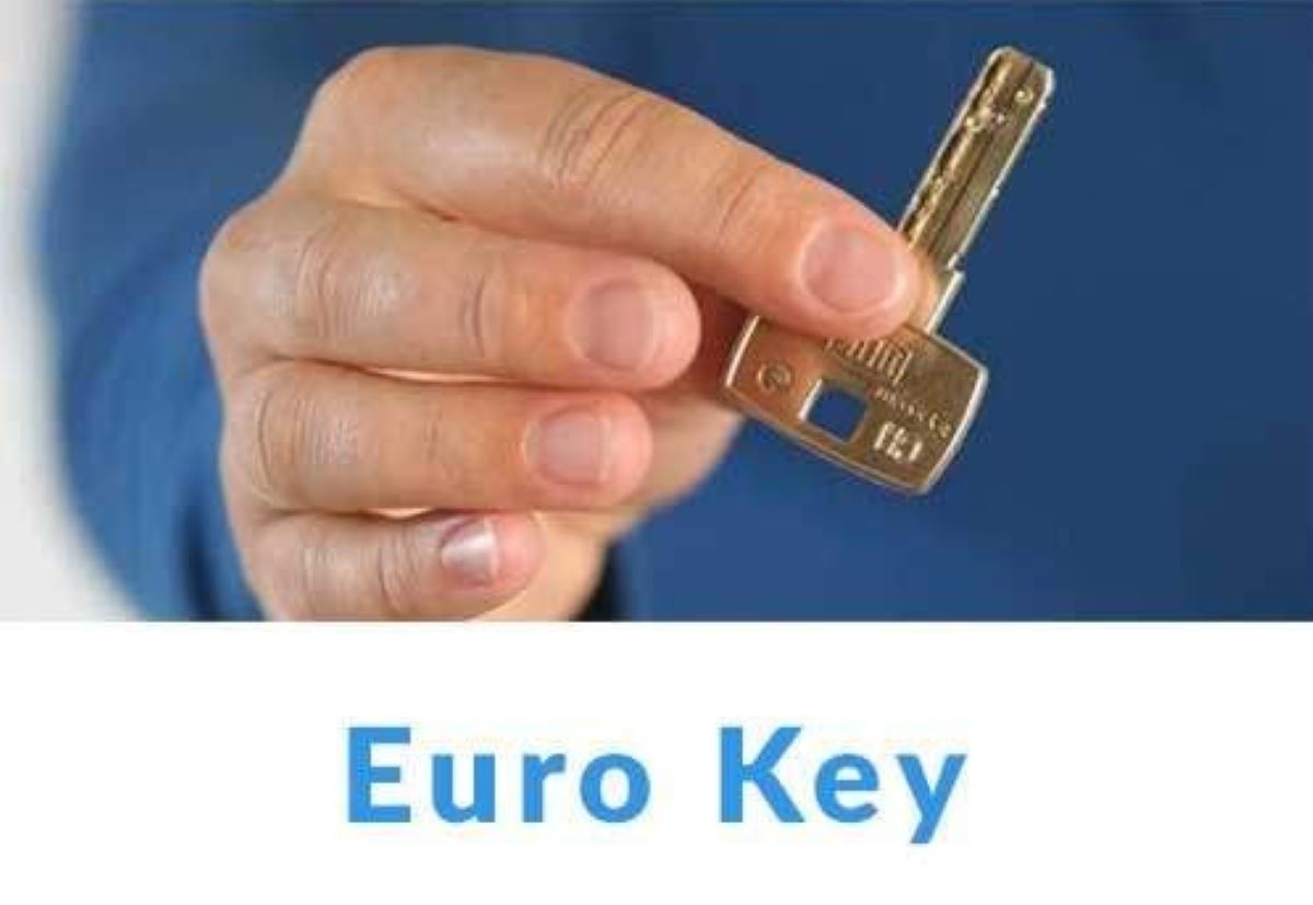Fotografija prikazuje krupni plan ruke koja drži metalni ključ s oznakom "Euro Key". Ključ ima pravokutnu glavu i nazubljenu oštricu, što sugerira da je dizajniran za specifičan tip brave – vjerojatno prema europskim standardima. Pozadina je zamućena, čime se pažnja usmjerava isključivo na ključ i ruku koja ga drži. Ispod fotografije nalazi se natpis "Euro Key" u plavoj boji, jasno istaknut. Ova fotografija vjerojatno služi za edukaciju ili promociju vezanu uz sigurnosne sustave, brave ili pristupne tehnologije.