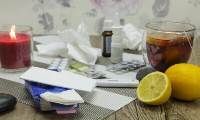 Na fotografiji se vidi stol prepun stvari koje se obično koriste kod prehlade ili gripe – pravi mali kutak za oporavak kod kuće.