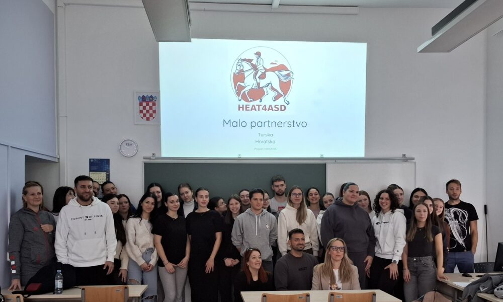 Na fotografiji se nalazi skupina ljudi, vjerojatno učenika i instruktora, okupljenih u učionici. Poziraju za zajedničku fotografiju ispred projekcijskog platna na kojem se prikazuje prezentacijski slajd. Na slajdu se nalazi logotip s prikazom osobe na konju i tekst "HEAT4ASD". Ispod logotipa piše: "Malo partnerstvo Turska Hrvatska Projekt 101135765" Ova oznaka upućuje na međunarodni projekt suradnje između Turske i Hrvatske, najvjerojatnije vezan uz obrazovanje ili istraživanje u okviru inicijative HEAT4ASD. U prostoriji se vidi hrvatski grb na zidu, sat i kalendar, što dodatno potvrđuje da se događaj odvija u Hrvatskoj.