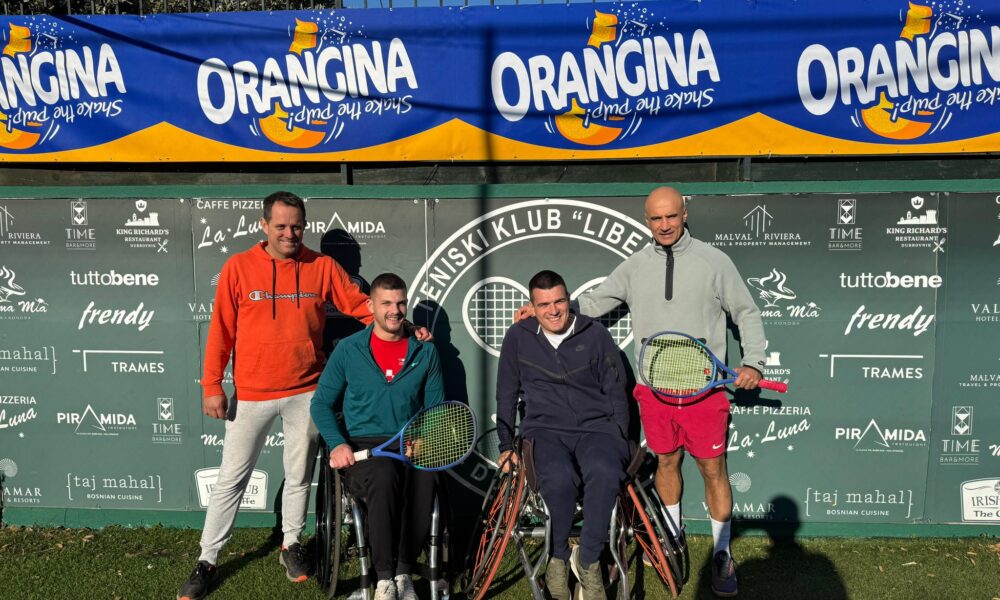 Fotografija prikazuje tenisače u kolicima i jednog čovjeka koji stoji iza njih.