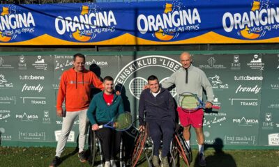 Fotografija prikazuje tenisače u kolicima i jednog čovjeka koji stoji iza njih.