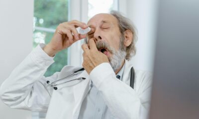 Fotografija prikazuje doktora koji si stavlja kapi u oči.