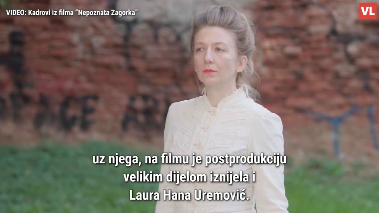 Na fotografiji je žena odjevena u vintage bijelu odjeću, stoji na otvorenom prostoru ispred zida od cigle prekrivenog grafitima. Pozadina je blago zamućena, čime se dodatno ističe žena kao središnji motiv. Njezin izgled i odjeća podsjećaju na povijesno razdoblje, što sugerira da je riječ o kadru iz filma. Preko slike je ispisan tekst na hrvatskom jeziku: „VIDEO: Kadrovi iz filma 'Nepoznata Zagorka'” „uz njega, na filmu je postprodukciju velikim dijelom iznijela i Laura Hana Uremović.” Ova fotografija vjerojatno prikazuje scenu iz filma koji tematizira život ili djelo Marije Jurić Zagorke, poznate hrvatske književnice i novinarke. Spominjanje Laure Hane Uremović u kontekstu postprodukcije upućuje na važnu ulogu koju je imala u stvaranju filma. Cjelokupni vizual ostavlja dojam umjetničkog i povijesnog prikaza, s naglaskom na žensku snagu i doprinos iza kamere.