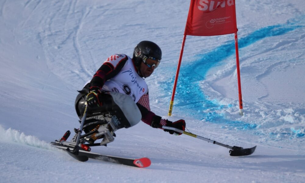 Fotografija prikazuje paraskijaša kako skija na skijaškoj stazi.