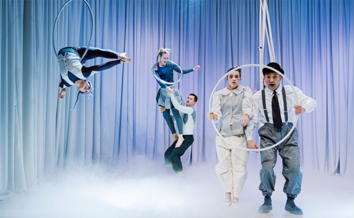 Izvođači na sceni izvode akrobacije s obručima u predstavi „Bijeli klaun“.