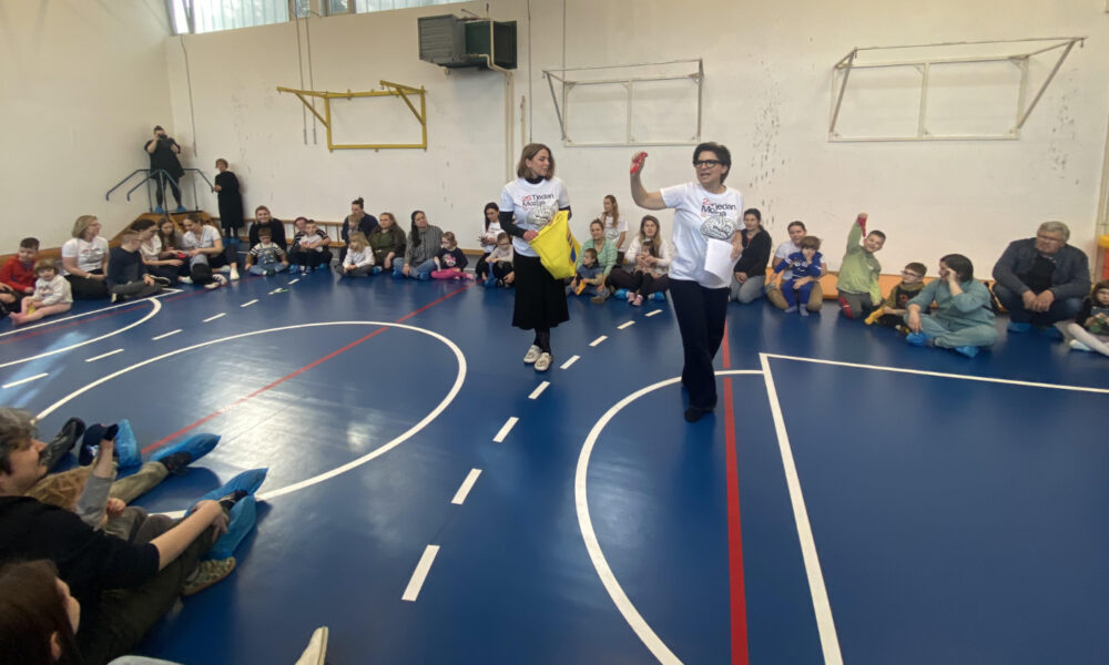 Djeca i odrasli sudjeluju u edukativnoj radionici u školskoj sportskoj dvorani.